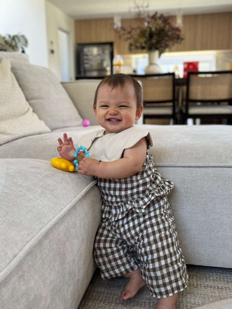 Millie smiling in a brown checkered outfit